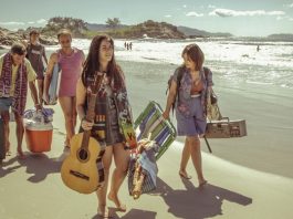 Filme “Sueño Florianópolis” tem pré-estreia nesta terça (13) cena do filme em que as pessoas estão andando na praia carregando malas de viagem