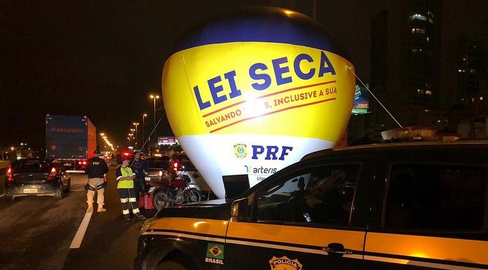 caminhonete da prf parada de noite na estrada ao lado de balão com inscrição da lei seca