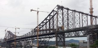 foto da ponte hercilio luz a partir da cabeceira continental no estreito em dia nublado mostrando as gruas da reforma