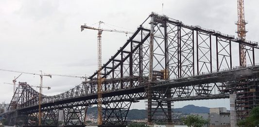 foto da ponte hercilio luz a partir da cabeceira continental no estreito em dia nublado mostrando as gruas da reforma