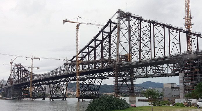 foto da ponte hercilio luz a partir da cabeceira continental no estreito em dia nublado mostrando as gruas da reforma