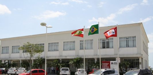 Duas chapas foram inscritas para a eleição da Câmara de Vereadores fachada do prédio da camara com alguns carros estacionados à frente e bandeiras hasteadas