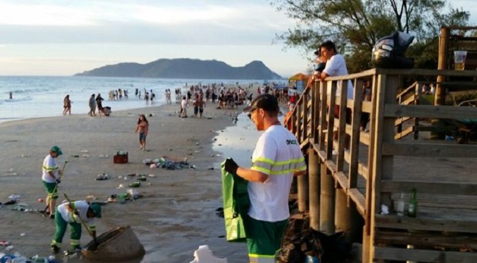 garis da comcap recolhendo muito lixo espalhado na praia do campeche, em florianópolis