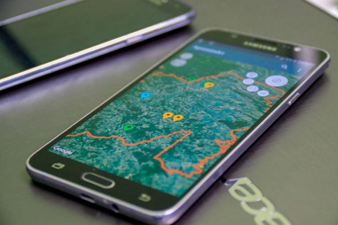 smartphone sobre uma mesa com um mapa de uma cidade na tela e pontos marcados