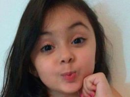 menina sorrindo e mandando beijinho para a câmera