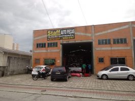 fachada da loja (galpão) onde há carros estacionados e uma placa escrita "staff autopeças"