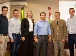 grupo posa sorridente para a foto em gabinete com bandeiras