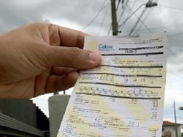 mão masculina segurando uma conta da celesc