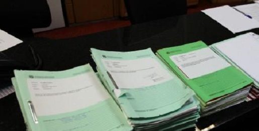 documentos de projetos empilhados sobre mesa