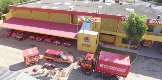 foto aérea de quartel dos bombeiros com veículos estacionados à frente e equipamento de resgate no chão