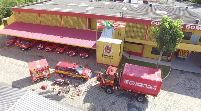 foto aérea de quartel dos bombeiros com veículos estacionados à frente e equipamento de resgate no chão