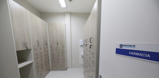 foto da porta e da sala de farmácia da nova upa, com armários cheios de gavetas