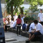jovens estudantes reunidos em pátio de colégio