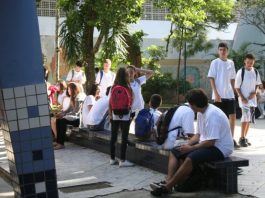jovens estudantes reunidos em pátio de colégio