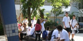 jovens estudantes reunidos em pátio de colégio