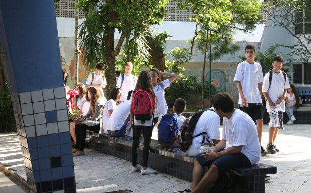 jovens estudantes reunidos em pátio de colégio