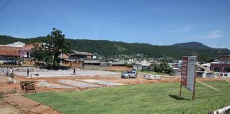 área aberta em construção a com gramado em pequeno declive no meio de uma área residencial