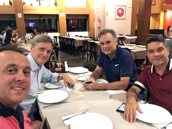 selfie tirada por juliano na mesa onde estão os quatro homens sorrindo para a foto