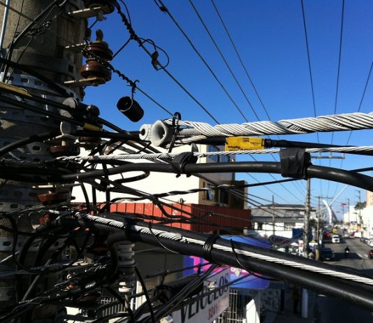 close no topo de um poste com dezenas de fios de energia emaranhados na avenida jousé di bernardi em são josé