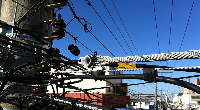 close no topo de um poste com dezenas de fios de energia emaranhados na avenida jousé di bernardi em são josé
