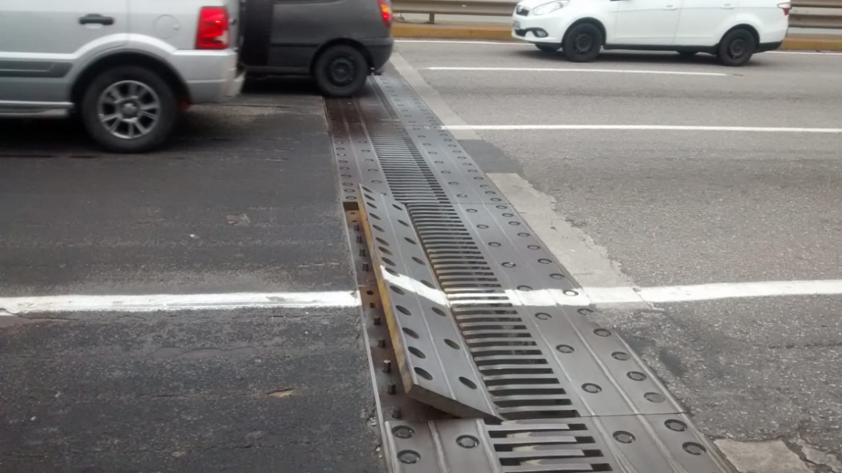 barra saliente para cima da junta de dilatação, no meio do asfalto