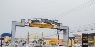 pórtico da avenida leoberto leal com placas de trânsito e carros passando em baixo em dia de chuva