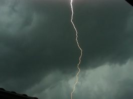 raio no meio de um céu totalmente nublado e cinza demonstrando risco de temporais e calor intenso