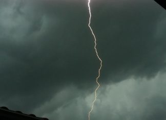 raio no meio de um céu totalmente nublado e cinza demonstrando risco de temporais e calor intenso