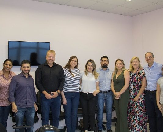 grupo de homens e mulheres posa para a câmera