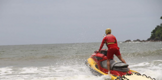 guarda-vidas em jet ski passando por ondas em uma praia