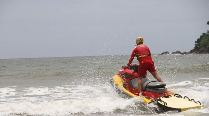 guarda-vidas em jet ski passando por ondas em uma praia