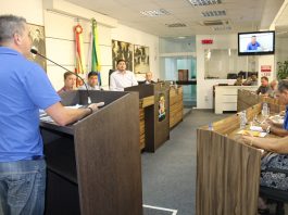 vereador roinoldo é visto por trás da tribuna falando aos demais no plenário da câmara