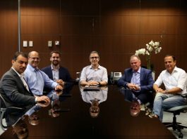 seis governadores em volta de uma mesa posa para a câmera com as bandeiras de sete estados ao fundo