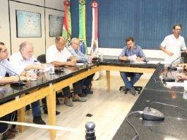 vereadores em uma sala reunidos em volta de uma bancada quadrada