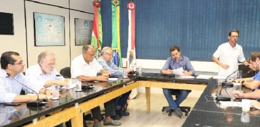 CPI do transporte, na Câmara de Florianópolis, coleta primeiros depoimentos vereadores em uma sala reunidos em volta de uma bancada quadrada