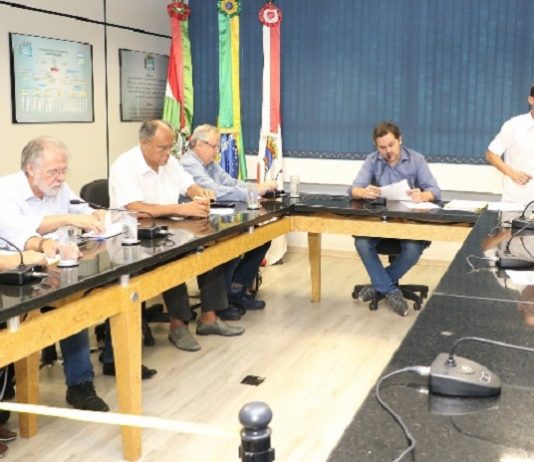 CPI do transporte, na Câmara de Florianópolis, coleta primeiros depoimentos vereadores em uma sala reunidos em volta de uma bancada quadrada