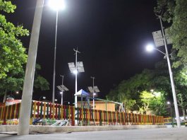 praça de palhoça com parquinho iluminada à noite