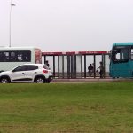 um ônibus da estrela atrás de um ônibus da jotur na beira-mar de são josé e um carro passando na frente