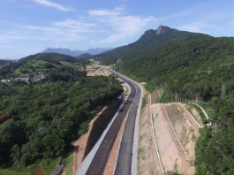 Justiça federal marca audiência para analisar obras do contorno viário obra do contorno viário vista do céu: duas pistas novas sem pintura cortando região de mata e morros