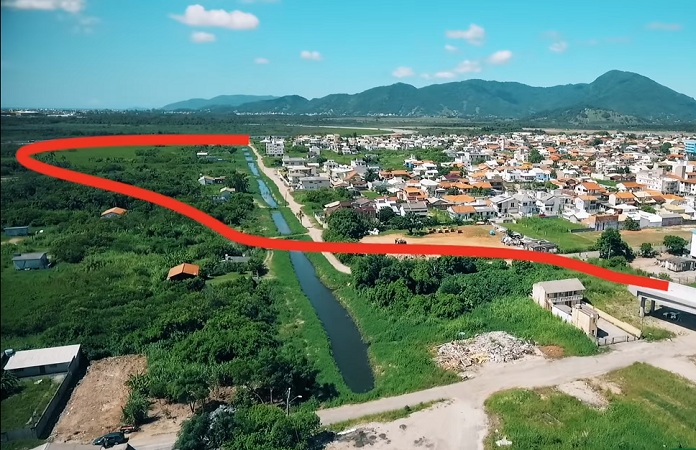 imagem aérea do bairro por onde vai passar a rodovia destacada com uma linha vermelha em curvas
