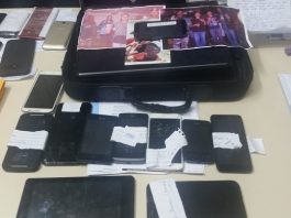 Polícias fazem operação na Vila Aparecida, em Florianópolis, nesta sexta mesa com objetos apreendidos, entre celulares e fotografias dos suspeitos