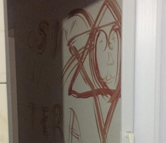 estrela de seis pontas desenhada em vermelho (sangue) na parede do apartamento e outras letras rabiscadas