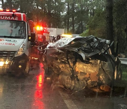 carro destruído no acostamento com ambulâncias ao lado