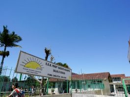 portão de entrada do colégio com placa com nome por extenso