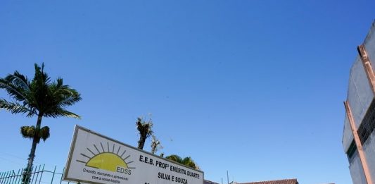 portão de entrada do colégio com placa com nome por extenso