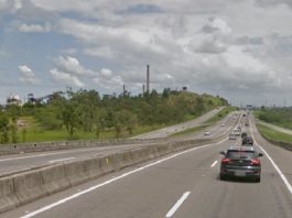 carros passando na rodovia que se estende ao longo da imagem