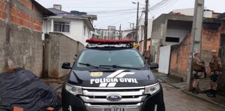 caminhonete ford edge da polícia parada em rua de favela com policias militares em volta