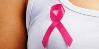 laço símbolo da campanha outubro rosa sobre o seio de uma mulher usando blusa