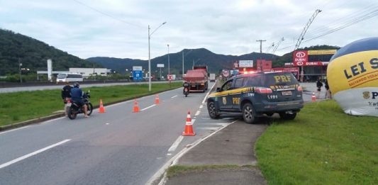 Rodovias federais tiveram aumento de vítimas fatais no feriado de Réveillon caminhonete da prf ao lado de balão inflável na lei seca sobre canteiro ao lado de marginal onde há cones