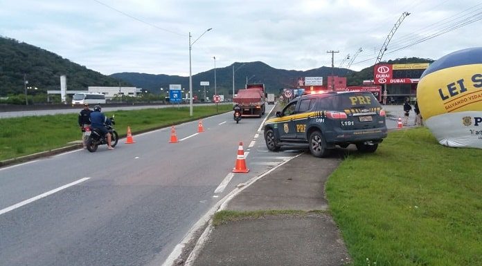 caminhonete da prf ao lado de balão inflável na lei seca sobre canteiro ao lado de marginal onde há cones